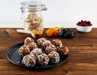 Various homemade raw vegan balls from oats, dates, figs, and cranberries on the plate. Close up.