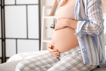Fototapeta na wymiar Beautiful young pregnant woman in bedroom