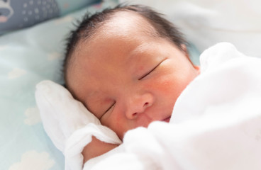 Fototapeta na wymiar The Sleeping cute New Born Baby infant on the bed