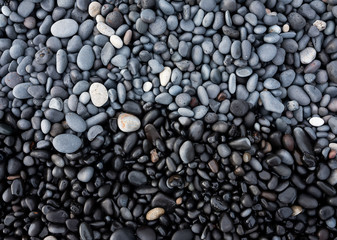 Fototapeta na wymiar Gray pebbles as a background in the Iceland sea shore. Abstract composition. Design - image