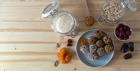 Plate with various homemade raw vegetarian energy bites. No bake, no artificial sweeteners. Easy tasty fitness snack. Top view, copy space