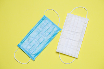 Blue and white medical surgical mask for protection against the virus on a colored background