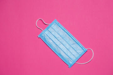 Blue medical surgical mask for protection against the virus on a colored background
