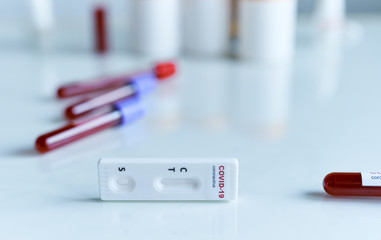 rapid or express test for COVID-19, lab card kit test for viral influenza. test tubes containing a blood sample on background. Testing for presence of coronavirus.