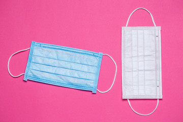 Blue and white medical surgical mask for protection against the virus on a colored background