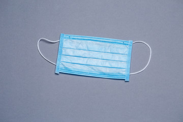 Blue medical surgical mask for protection against the virus on a colored background
