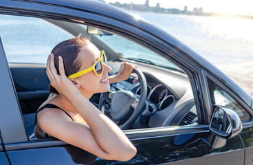 Naklejka premium Girl drives a car on a sunny day.