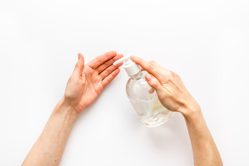 Disinfecting hands. Dispensing sanitizer on white background top view