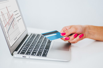 Hand holding credit card and using laptop. Businesswoman or entrepreneur working from home. Online...