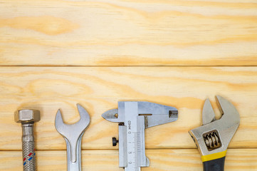Necessary set of tools for plumbers on wooden boards with space for advertising