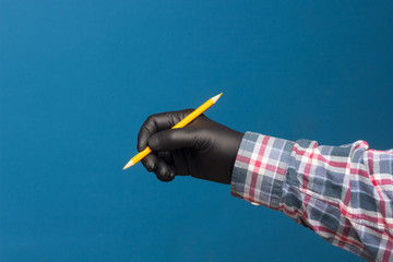 Color pencil in the hand of a person with black glove