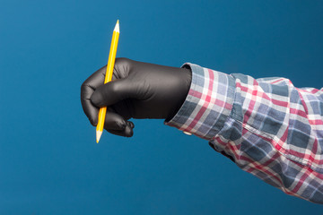 Color pencil in the hand of a person with black glove