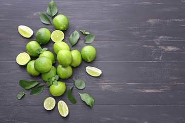 Fresh limes on dark wooden background