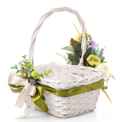 Fototapeta na wymiar Wicker basket with floral decor and ribbons on white background