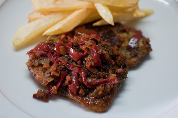 Breaded fillet with red pepper and fries potatoes

