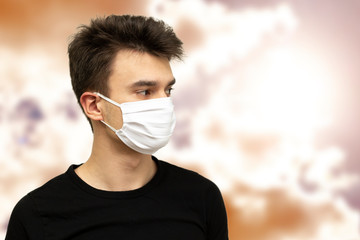 Man with medicinal mask and yellow clouds on background. Pollution concept. Man with medical protection.