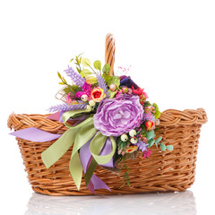 Fototapeta na wymiar Wicker basket decorated with colorful flowers and ribbons. Isolated