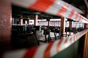 the food court of the shopping center is closed for quarantine, due to threat of coronavirus, access to restaurant, cafe is prohibited for duration of pandemic, seats are blocked with a warning tape