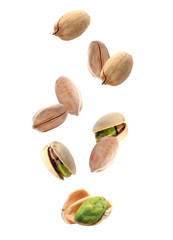 Tasty pistachio nuts falling on white background