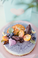 Raw vegan cake with fruits, seeds, chocolate and flower decoration