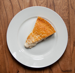 Homemade cheesecake on white plate and wooden table