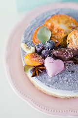 Raw vegan cake with fruits, seeds, chocolate and flower decoration