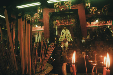 Incense stick burning in foreground with in altar blurred in background. Hong Kong temple