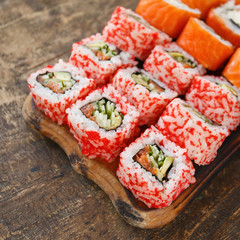 Two different kinds of sushi rolls on a wooden board. Japanese cuisine