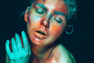 Art make up body art woman face unusial red skin blue green hair and hand face close up ufo