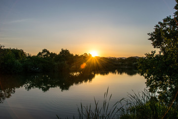 Naklejka na ściany i meble Silhouetted sunset on lake, Kruger National Park, South Africa