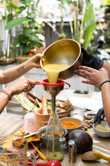 jamu traditional. close up of hand fill in the bottle with indonesian javanese traditional herbal drink jamu