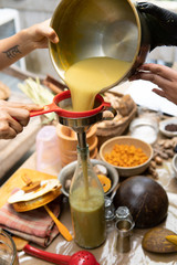 jamu traditional. close up of hand fill in the bottle with indonesian javanese traditional herbal drink jamu