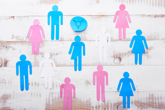 Human figures with symbol of transgender on white wooden background. Concept of transgender