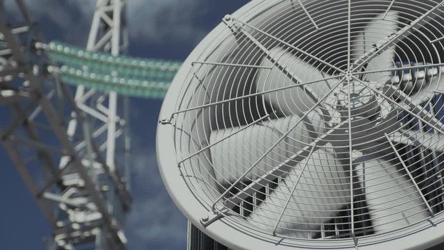 Large industrial fan on a high voltage transformer against the background of a cloudy sky and high-voltage wires with insulators.