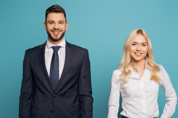 young, smiling couple of businesspeople looking at camera isolated on blue