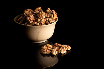 Walnut dry fruits in a brown bowl against dark background