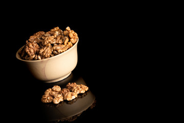 Walnut dry fruits in a brown bowl against dark background