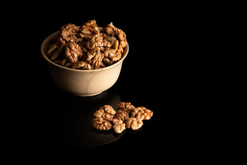 Walnut dry fruits in a brown bowl against dark background