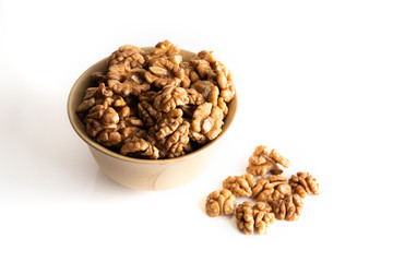 Walnut dry fruits in a brown bowl against a white background