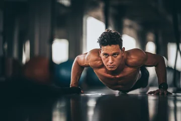 Foto op Canvas Muscular and strong athletic man doing Push up exercising in sport gym. © chokniti