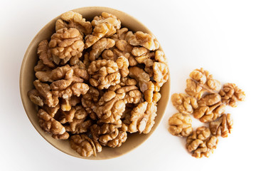 Walnut dry fruits in a brown bowl against a white background