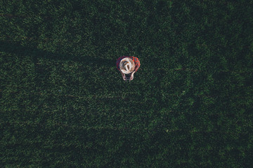 Wheat farmer using drone remote controller in wheatgrass field, aerial