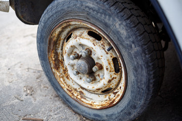 Rusty wheel with a tire from a car. Abandoned car tire.