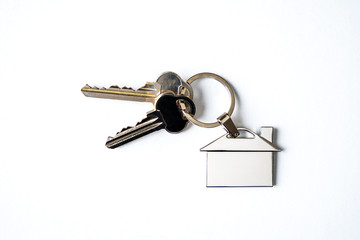 House keys with house key chain isolated on white background, to illustrate the purchase of a new house, home rental or personal security concepts.