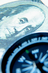 The path to success and wealth concept. Сompass and US dollar bills. Selective focus on banknote.