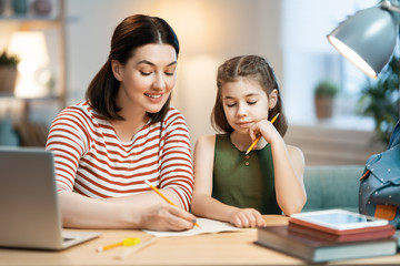 Girl doing homework with mother