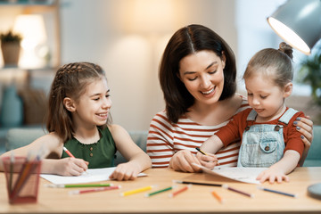 Fototapeta premium Mother and daughters are drawing together