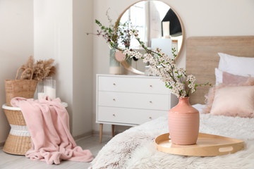 Interior of beautiful modern bedroom with spring flowers