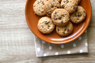 Chocolate chip cookies and polka dot napkin on wooden table. Top view.