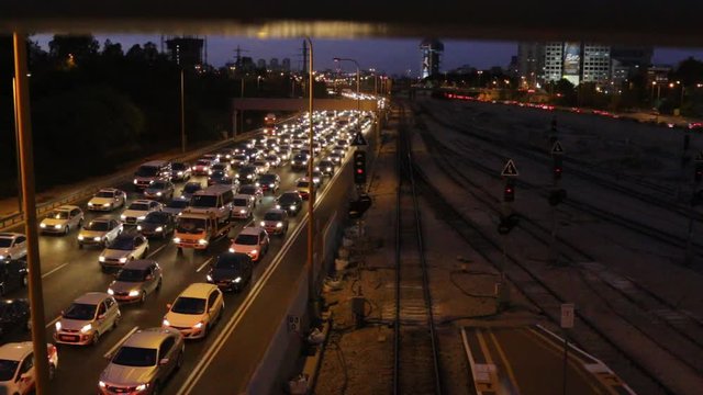 Traffic at night in Ayalon Highway in Israel. cars, tracks, bikes moving slowly with headlights on.